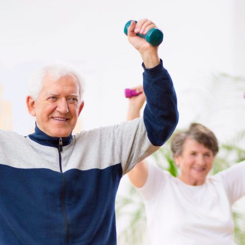 Two elderly patients exercising with weights in rehabilitation center